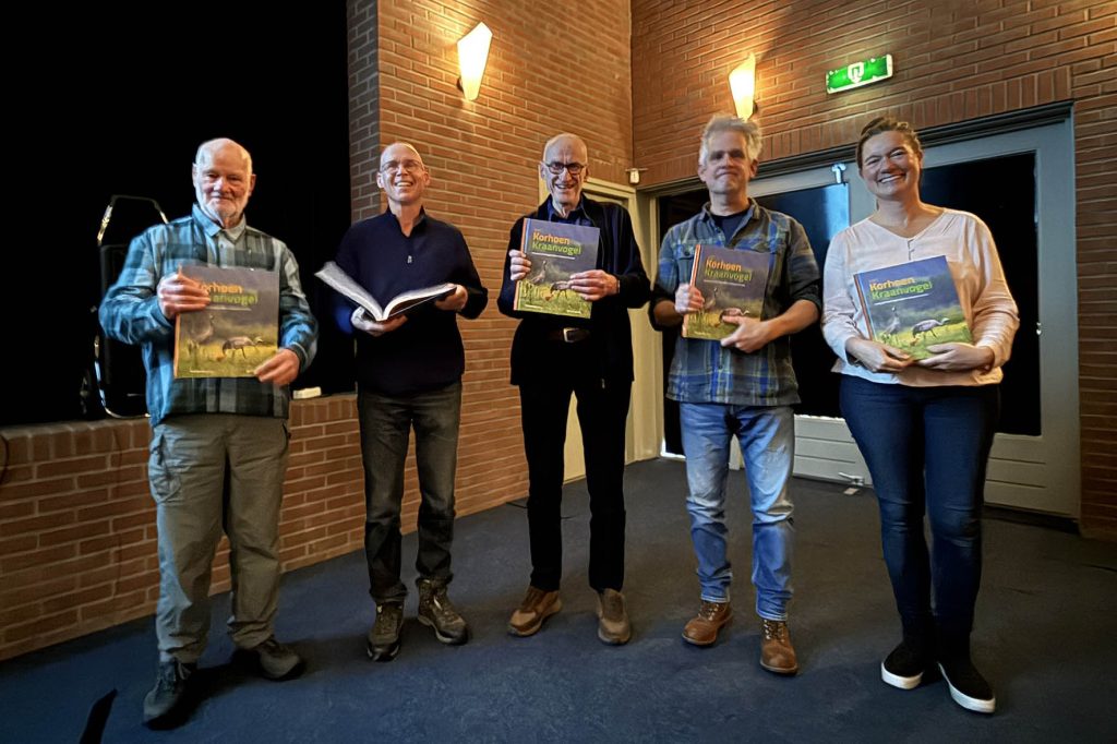 De vijf leden van de werkgroep poseren met het boek dat Vogelwacht-voorzitter Simon Bijl hun heeft overhandigd. Arend van Dijk, Willem van Manen, Joop Kleine, Norbert Kwint en Sanne van Gemerden zijn er zichtbaar blij mee