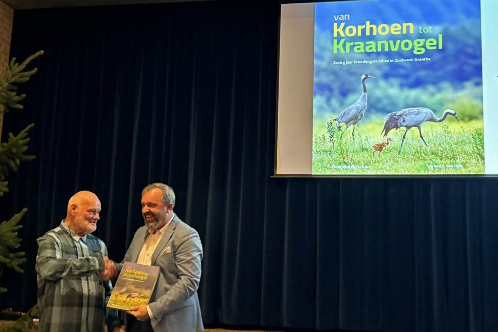 Uit handen van Arend van Dijk ontvangt de Drentse gedeputeerde Egbert van Dijk (geen familie) het eerste exemplaar van het boek van Korhoen tot Kraanvogel.